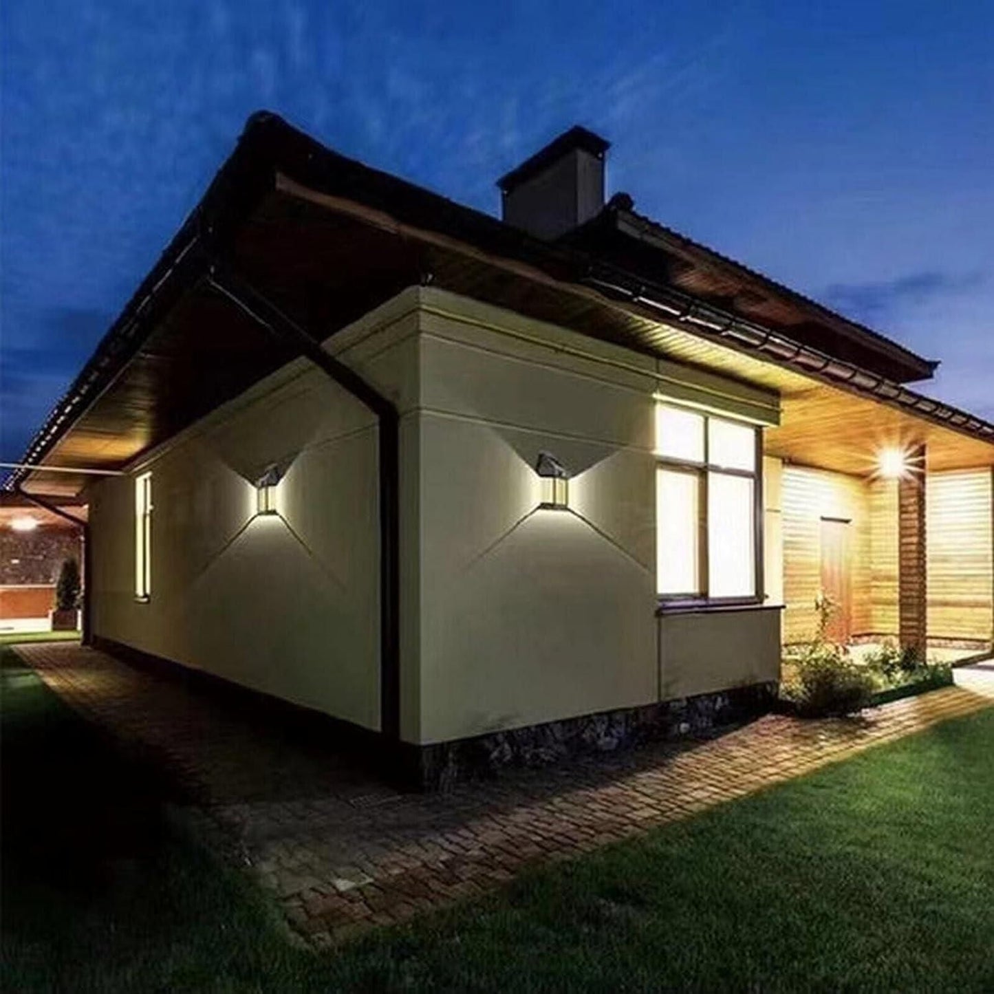 Modern house exterior with energy-efficient garden lighting illuminating walls and pathways at night