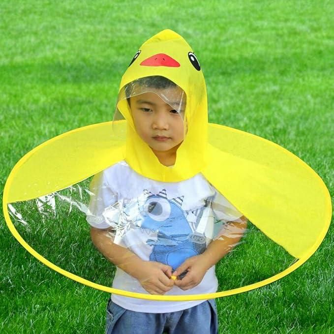 Kid wearing bright yellow kid's duck rain cover with clear plastic front in outdoor grassy area