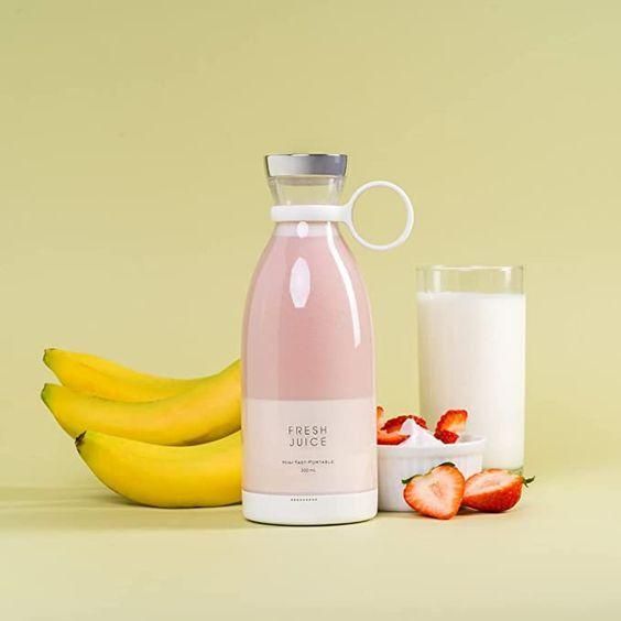 Livingdot portable mini juice blender with pink juice next to bananas strawberries and a glass of milk