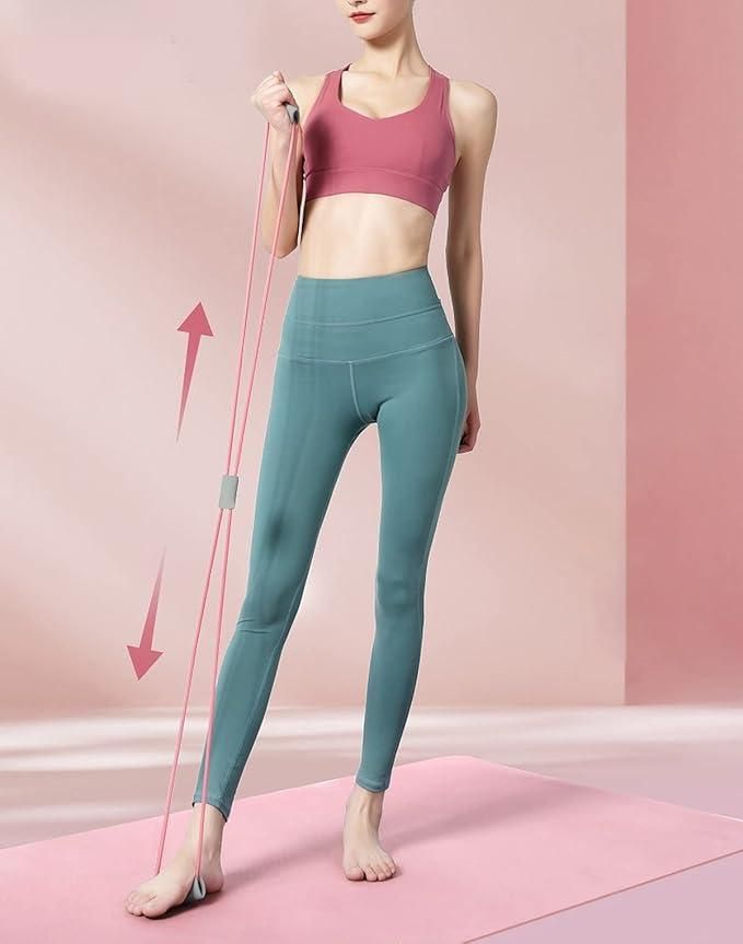 Woman using resistance bands for home gym in pink and green workout clothes on a pink mat