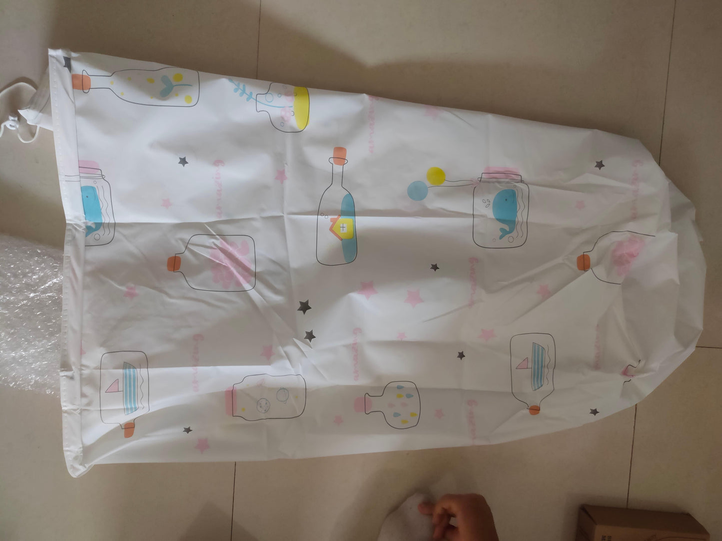 Livingdot round quilt storage bag with colorful bottles and star patterns on white fabric