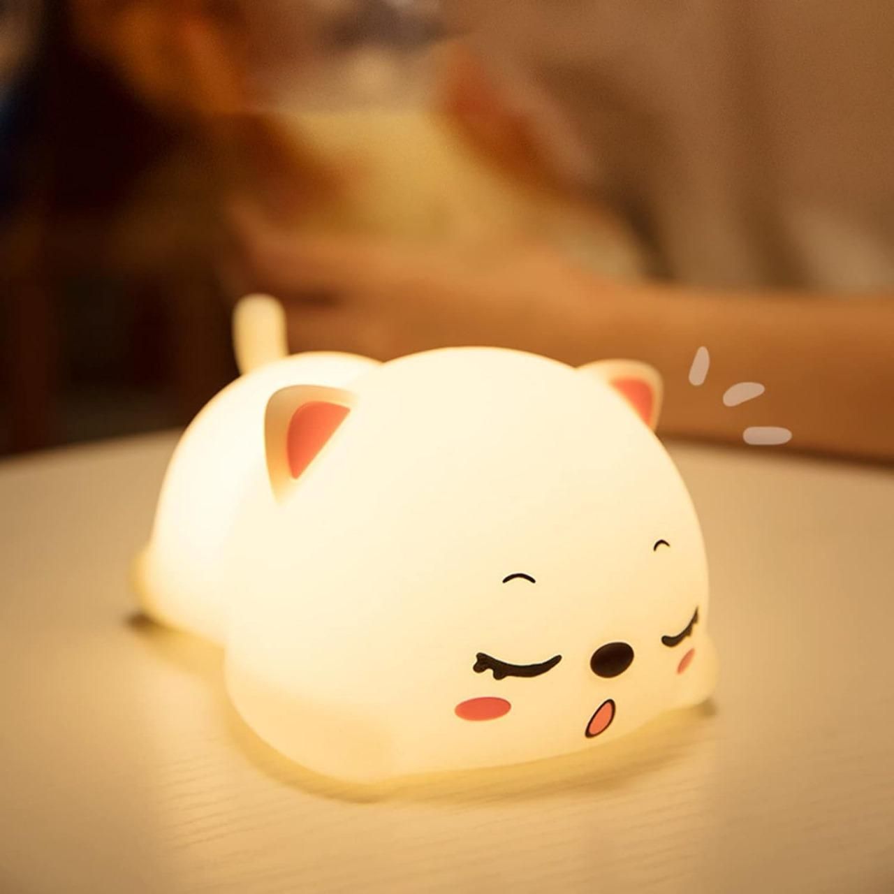 Soft glow cat light for kids shaped like a sleepy white cat with pink ears and cheeks