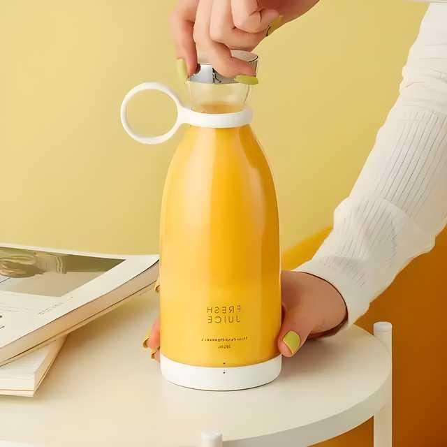 Livingdot portable mini juice blender in yellow with white base and cap held by a person on a white table
